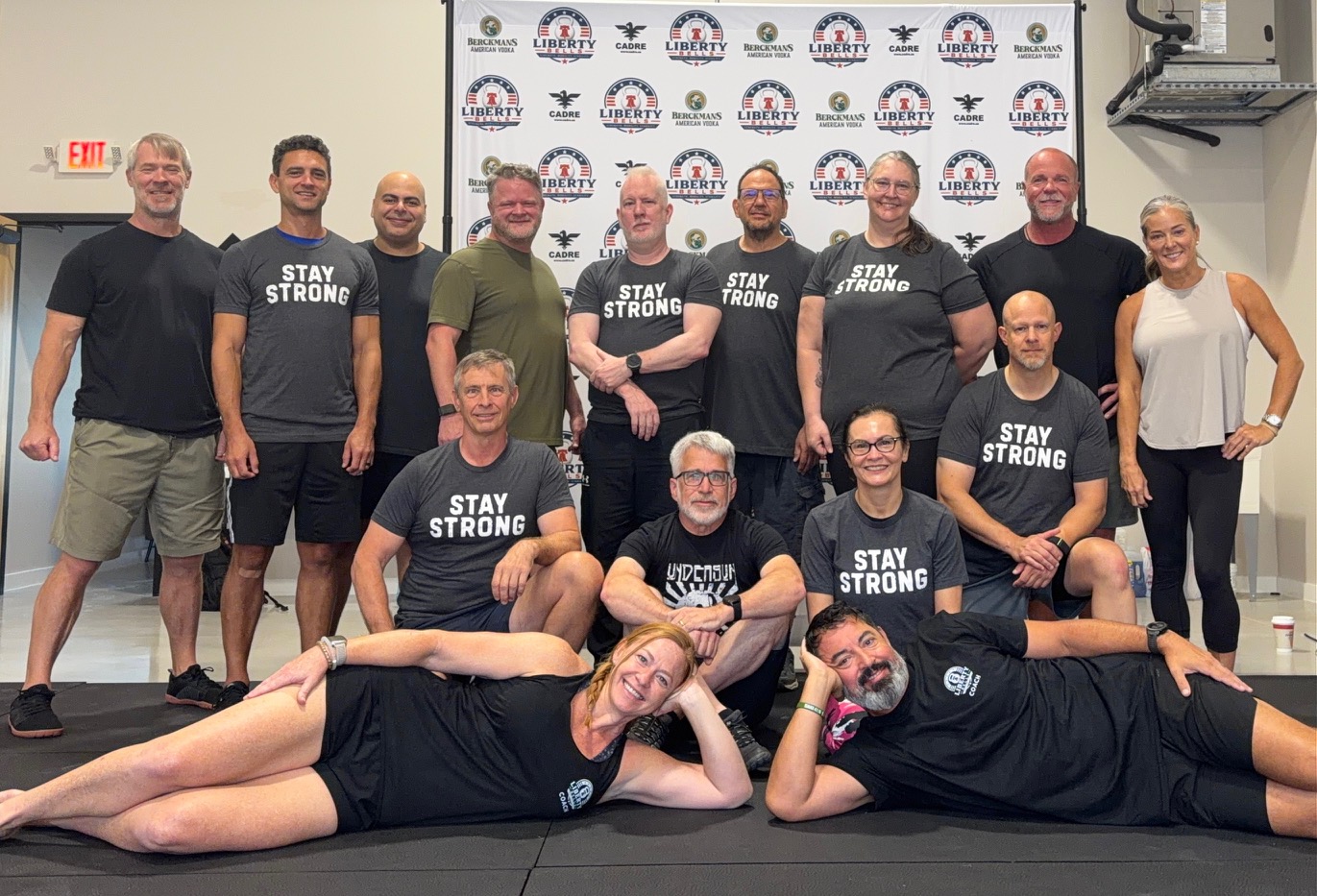 Group photo of workshop attendees in Stay Strong shirts in front of the Liberty Bells backdrop