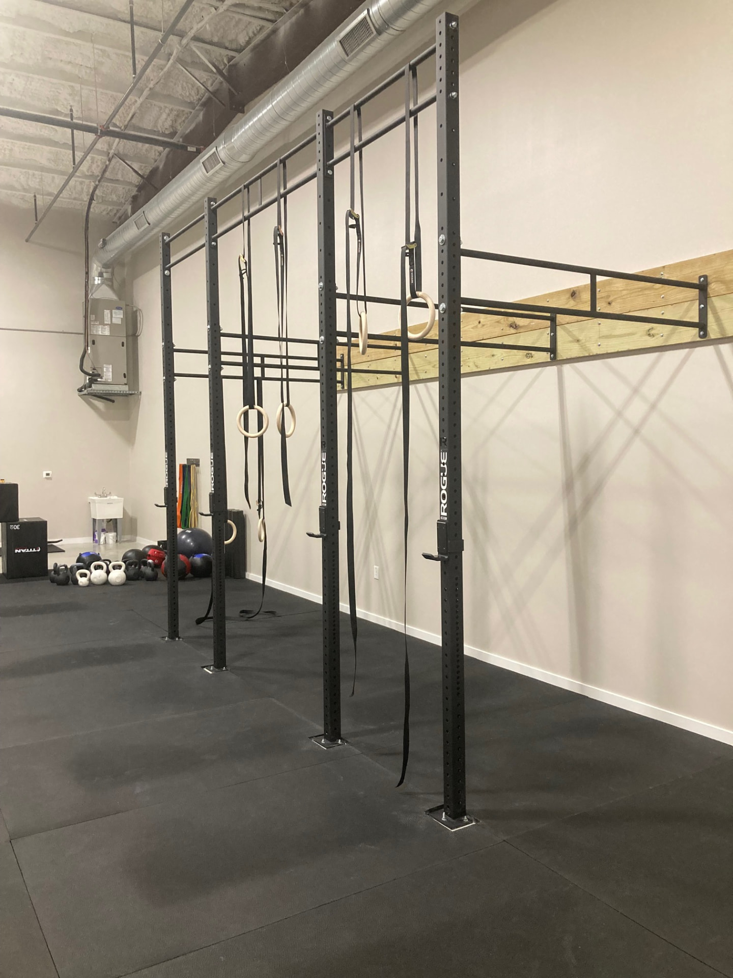 Rogue rig with gymnastic rings and kettlebells on the Liberty Bells training floor