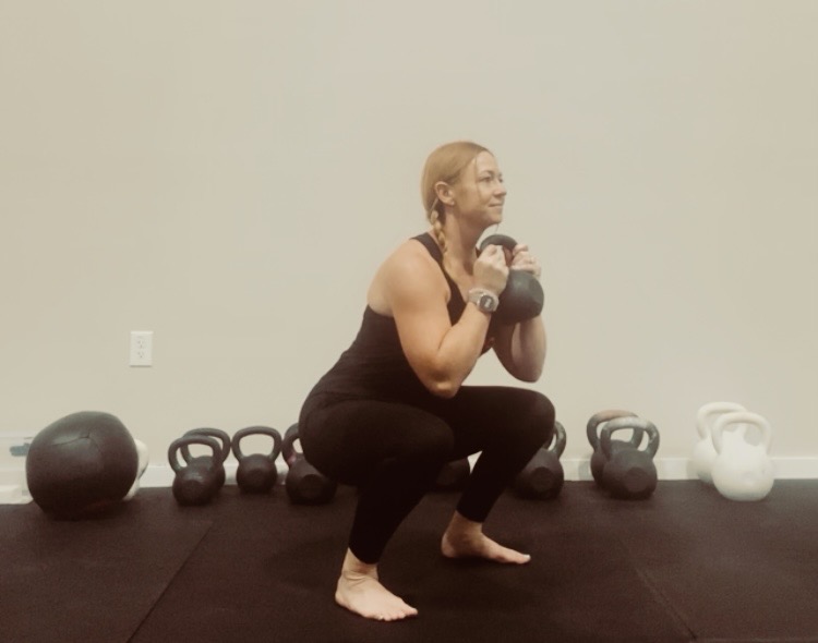 Deep goblet squat with a kettlebell at Liberty Bells in Leander, TX