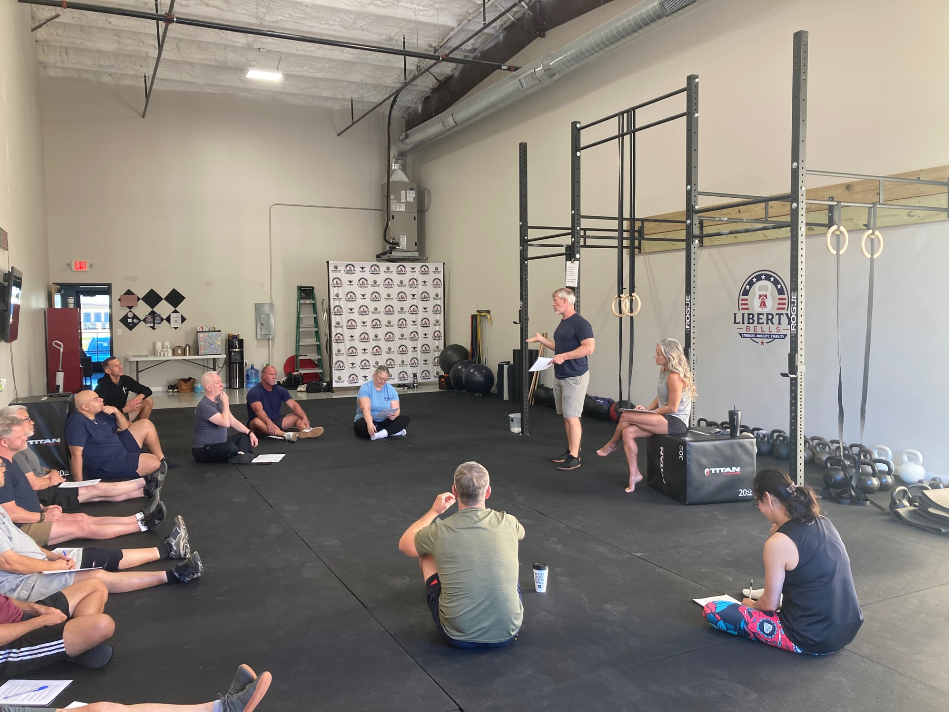 Workshop group seated on the training floor listening to a coach at Liberty Bells in Leander, TX