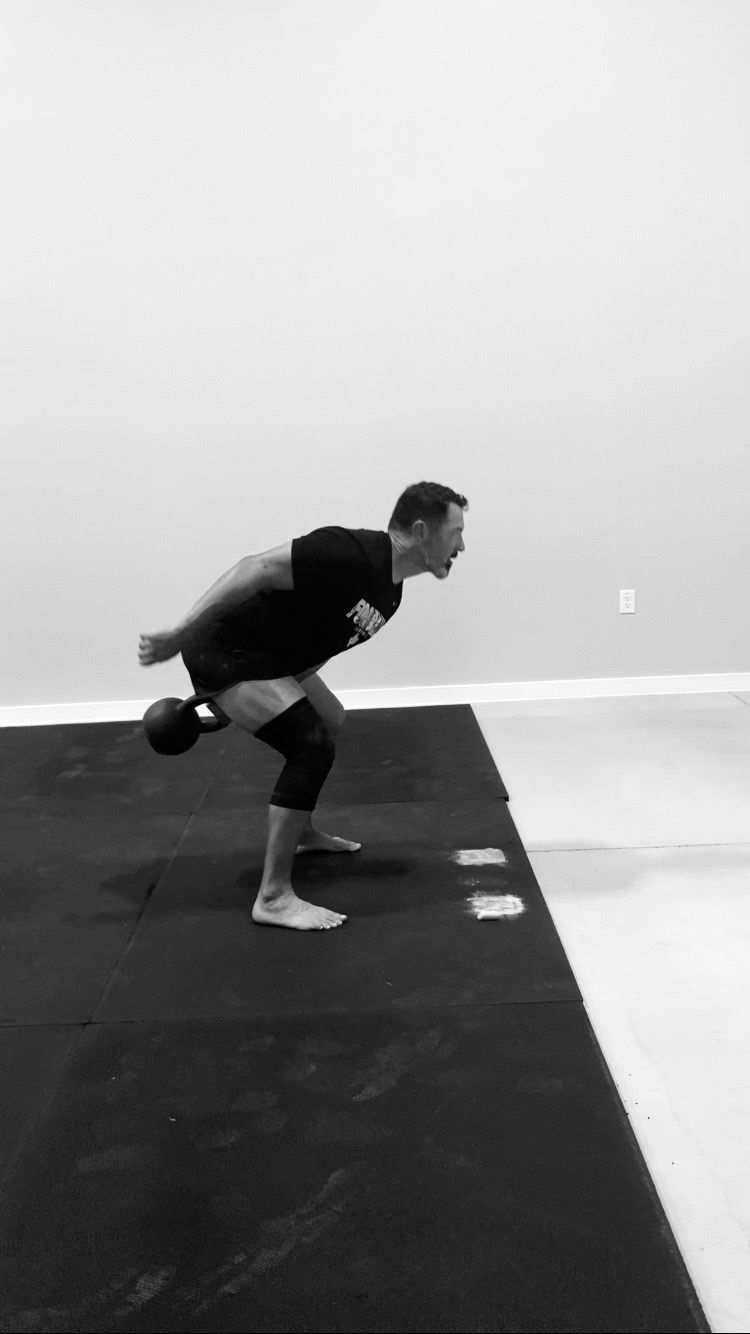 Hiking a kettlebell back for a swing at Liberty Bells in Leander, TX